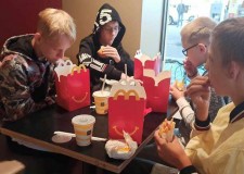 Powiększ zdjęcie chłopcy jedzą przy stoliku w McDonald